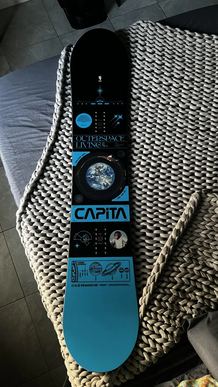 The full Capita Outerspace Living deck photographed on a rug