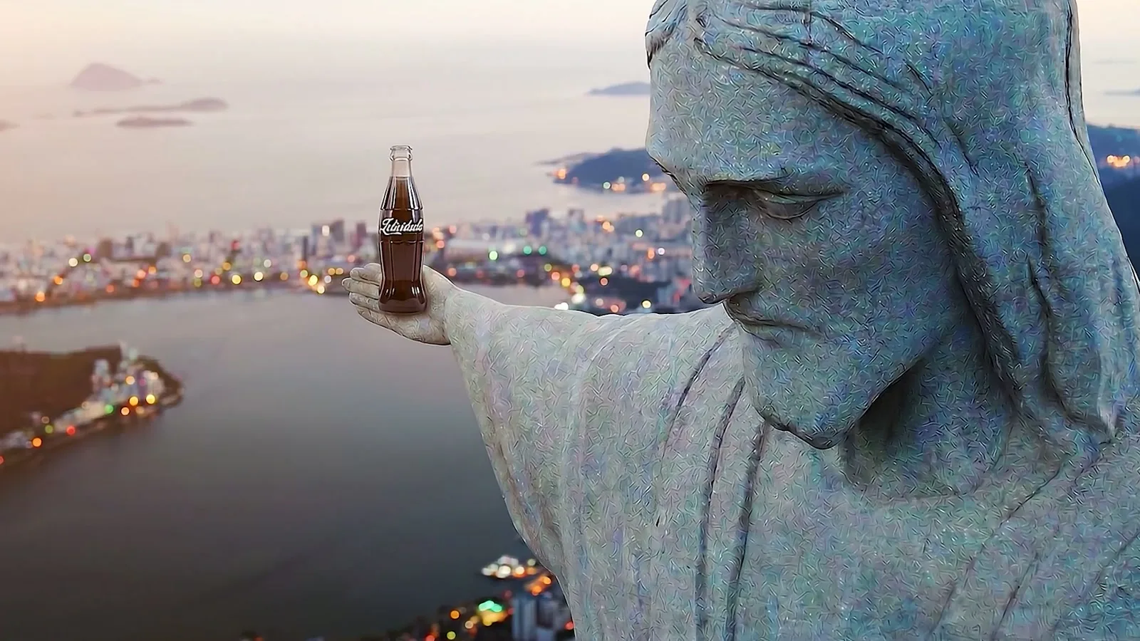 Frame from the film, Cristo Redentor holding a Coca-Cola bottle reading Felicidade over the bay