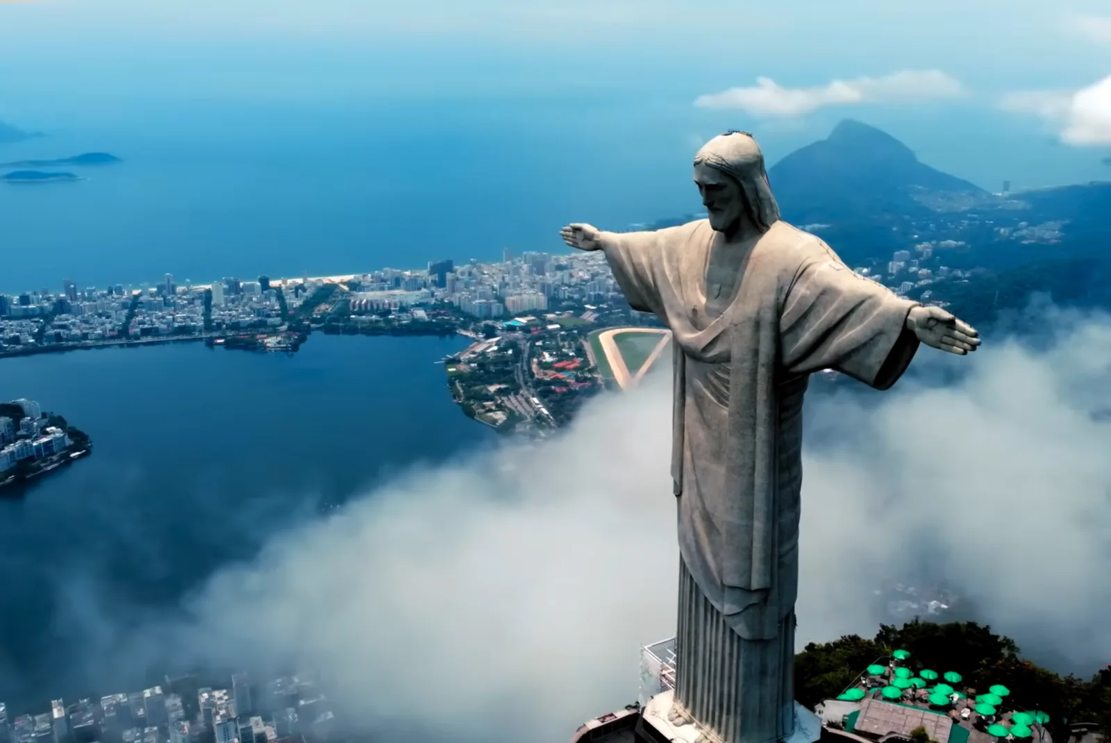 Photograph of Cristo Redentor above Rio de Janeiro, arms open over the clouds