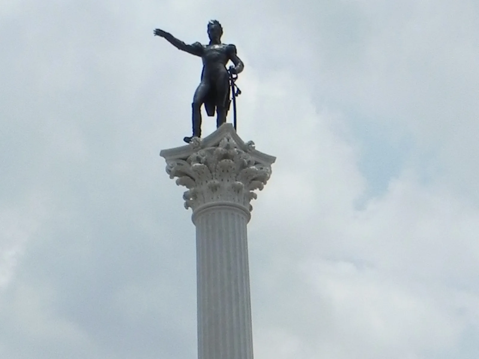Photograph of the Bolívar statue atop its column in Plaza Bolívar, Valencia, arm outstretched